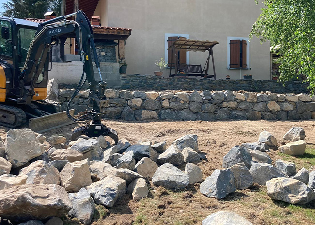 Muret composé de blocs de pierre dans un jardin en cours d’aménagement